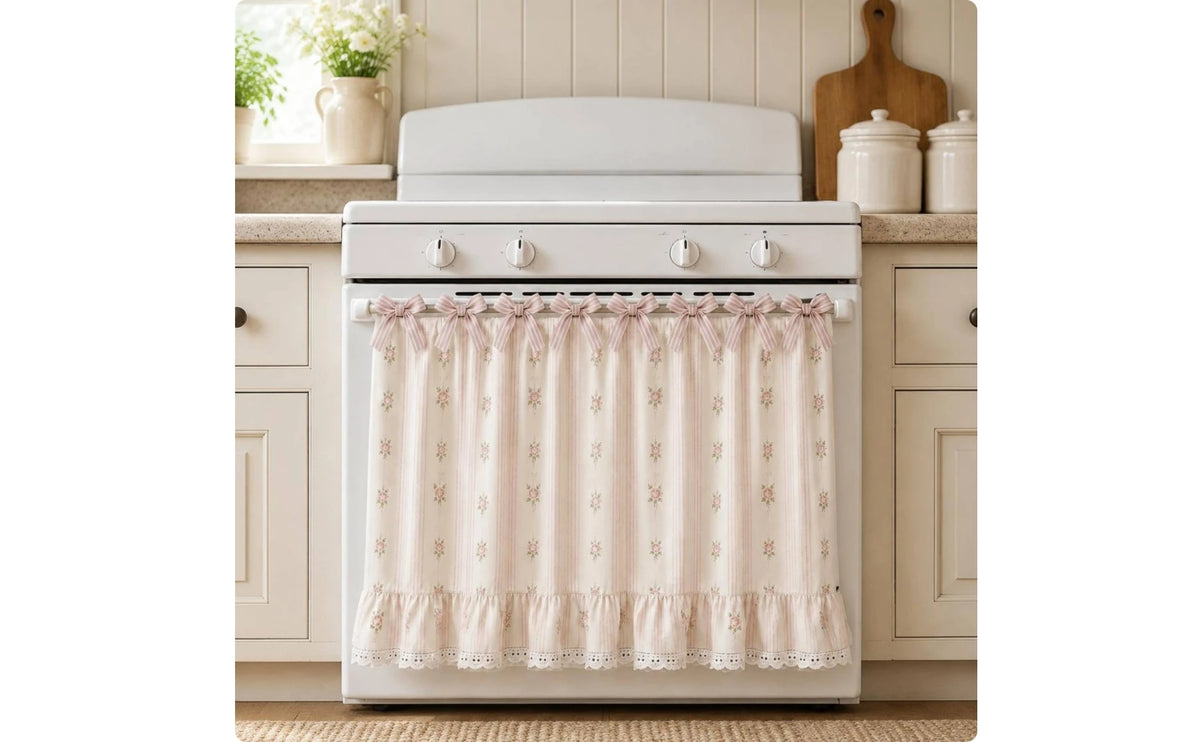 A white farmhouse oven skirt with a floral pattern and ruffle trim is installed below a white stove top.