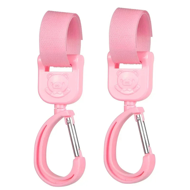 A pair of pink 360° rotating stroller hooks designed for hanging bags and essentials.