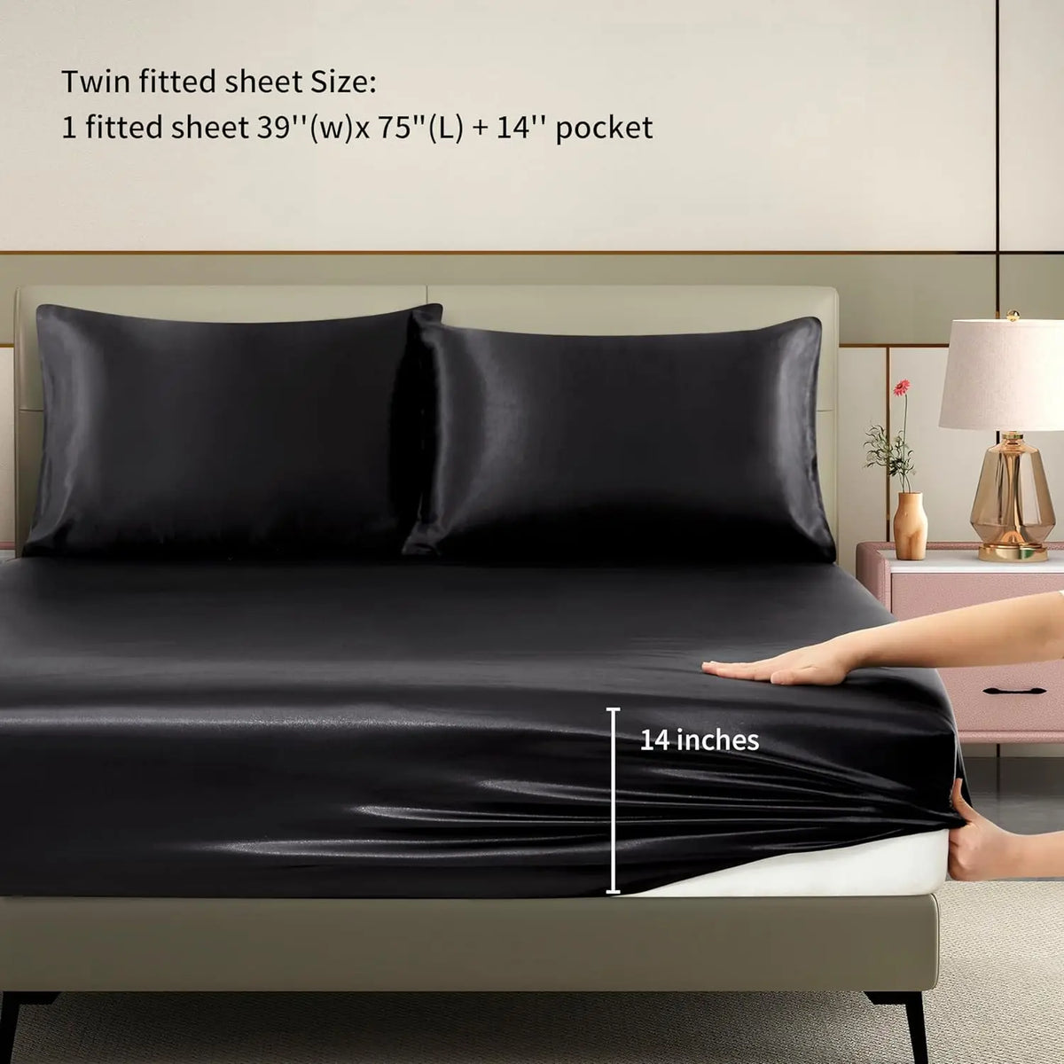Black satin fitted sheet with a 14 inch depth shown on a bed.