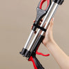 A hand holds a red and black foldable grabber tool with silver arms, demonstrating its use for cleanup.