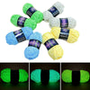 A collection of glow-in-the-dark polyester yarn in various shades of green, blue, and yellow, packaged with labels.