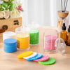 A collection of colorful compressed natural sponge pats in various shades are displayed on a wooden surface.