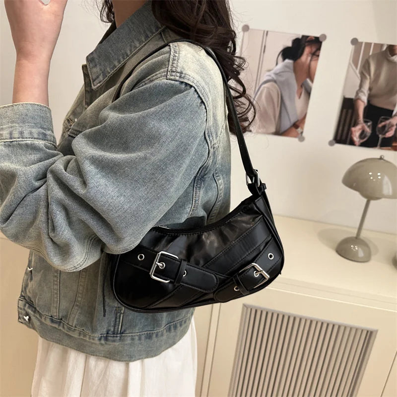 A woman wearing a denim jacket holds a black PU leather crossbody bag.