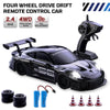A black four-wheel drive drift remote control car with accessories and tire replacement parts.