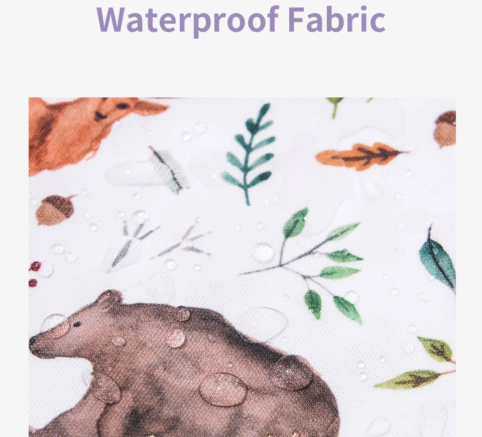 Close-up of a brown bear illustration on a white fabric featuring water droplets and green foliage.