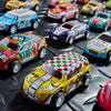 A collection of die-cast pull-back racing cars in various colors and designs displayed on a dark surface.