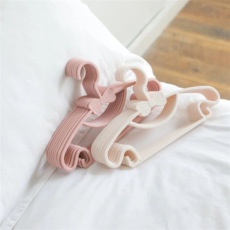 Rosa und weiße, verstellbare Plastikkleiderhaken zur Kleiderschränkkorganisation
