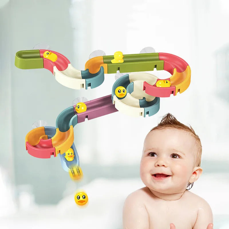 A baby is looking up at a colorful bath time duck slide toy set with various colored plastic components.