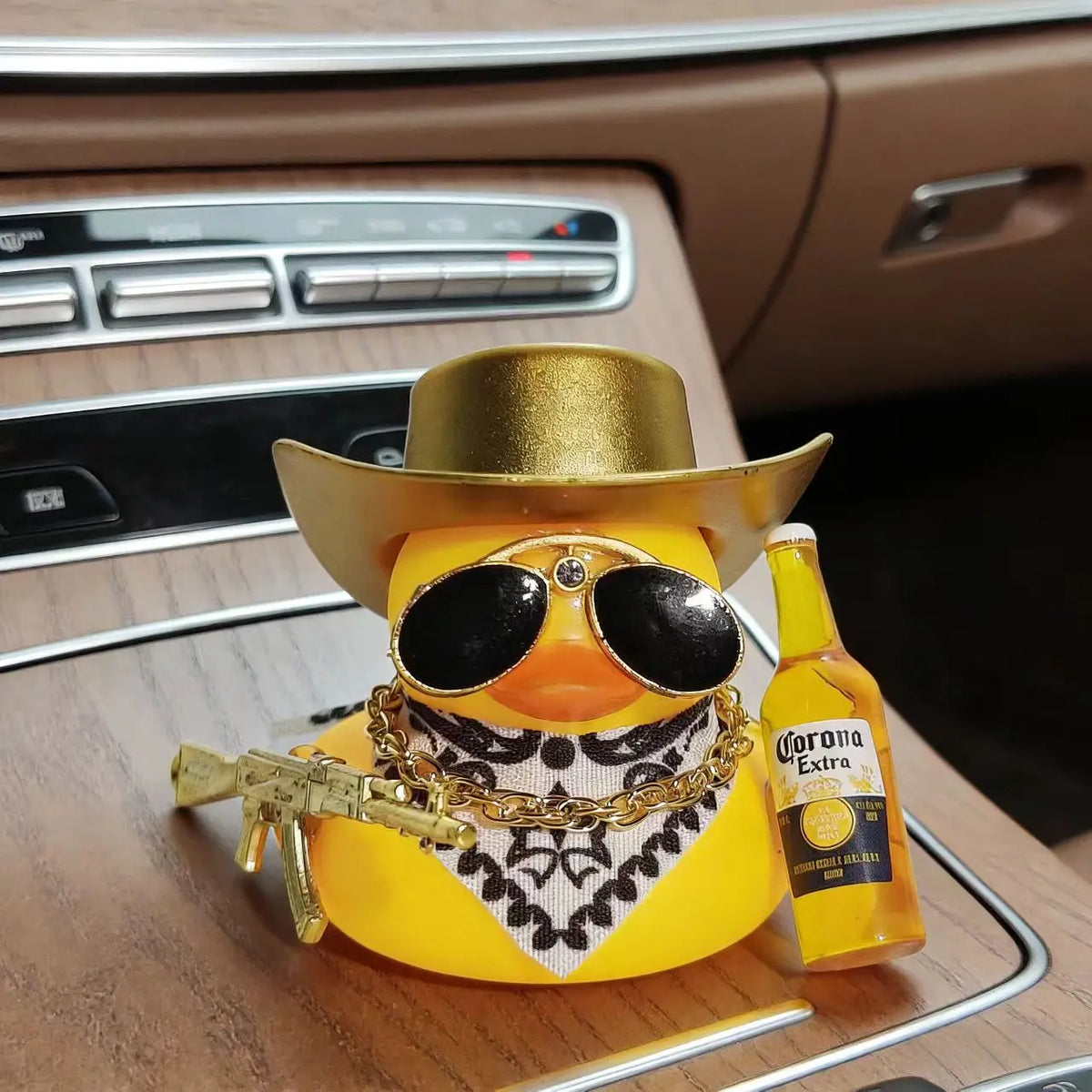 A yellow rubber duck car ornament wearing sunglasses and a cowboy hat sits on a dashboard.