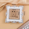 A rectangular switch cover frame with an elegant rose pattern border and a brown electrical outlet.
