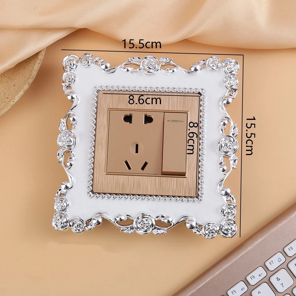 A rectangular switch cover frame with an elegant rose pattern border and a brown electrical outlet.
