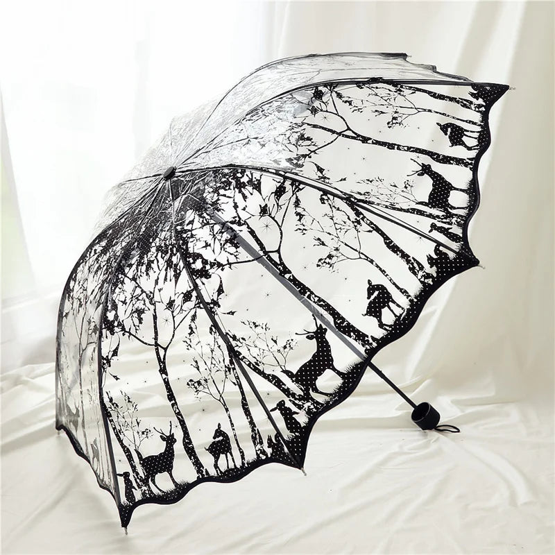 A transparent umbrella with a black frame features a silhouette design of various animals and trees.