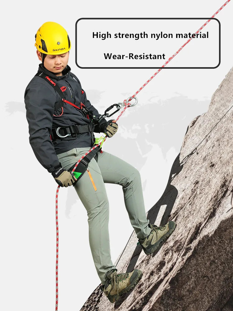 A man wearing a yellow helmet and climbing gear is shown using a red rope on a rocky cliff face.