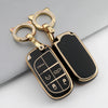 A gold-toned key ring with a black TPU car key case cover featuring various key shapes.