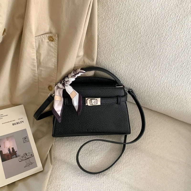 Schwarze elegante PU-Leder-Clutchtasche mit rosa-weiß gestreifter Schleifenverzierung auf cremefarbigem Stoff.