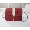 A maroon compact crossbody handbag with a light beige strap and gold chain detail.