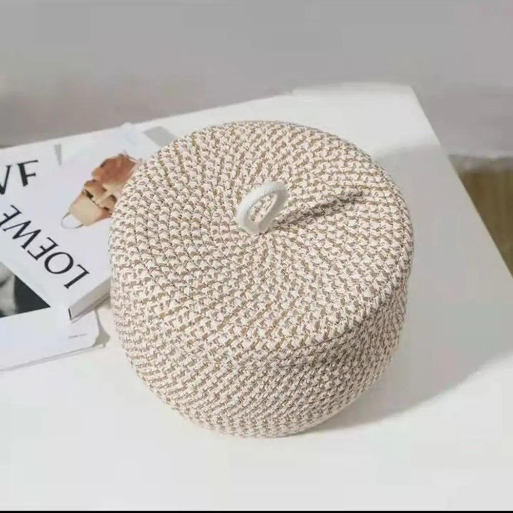 Runde, beige handgewebte Baumwollkorb mit Deckel auf weißer Oberfläche.