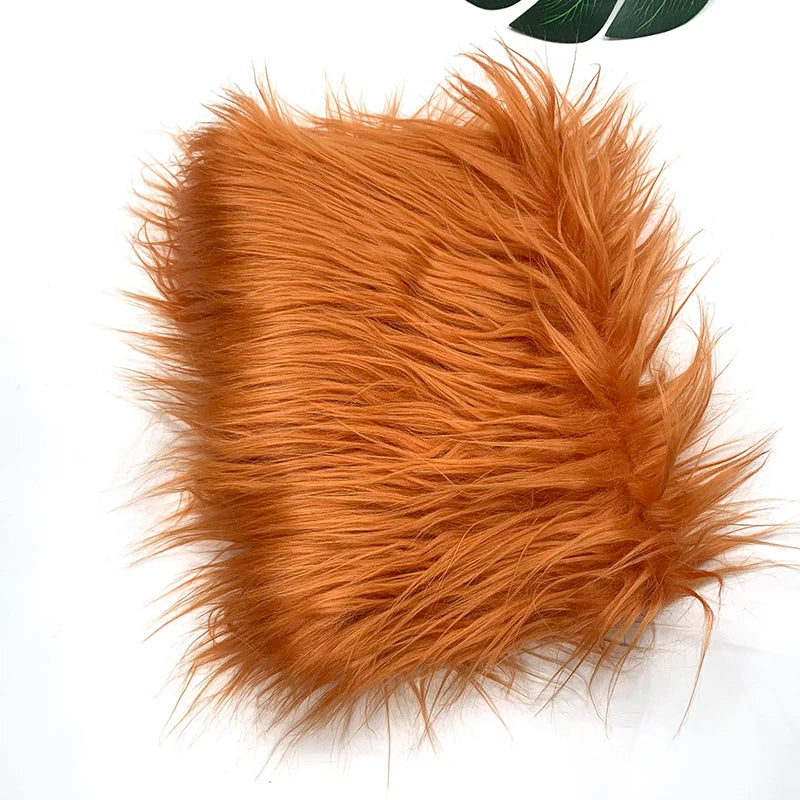 A close-up of fluffy orange faux fur fabric used for DIY sewing, doll hair, and cosplay.