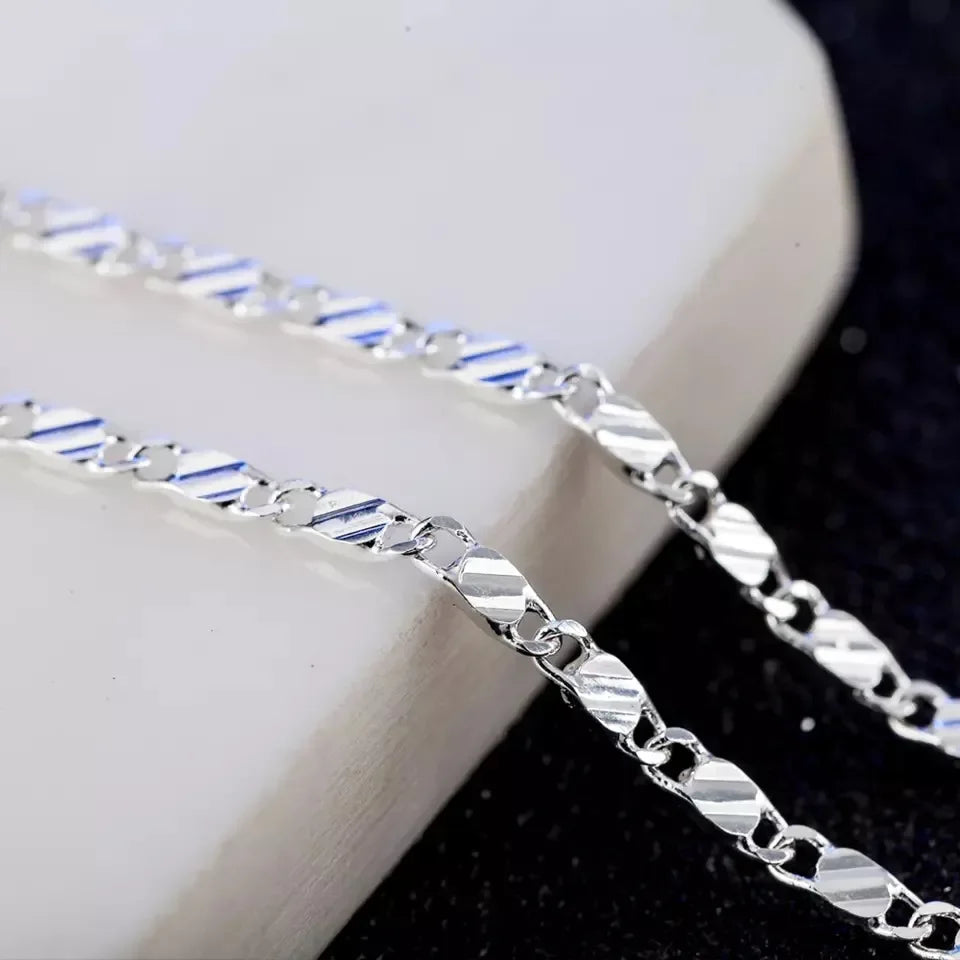 A silver side chain necklace with 18k gold plating is displayed on a white background.