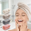 A woman is relaxing and applying a hair towel wrap to her head, surrounded by various colored microfiber hair towels.