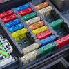 An assortment of car blade fuses in various colors and amperages stored in a plastic box.