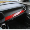 Interior view of a car with red trim accents on the dashboard and door panel.