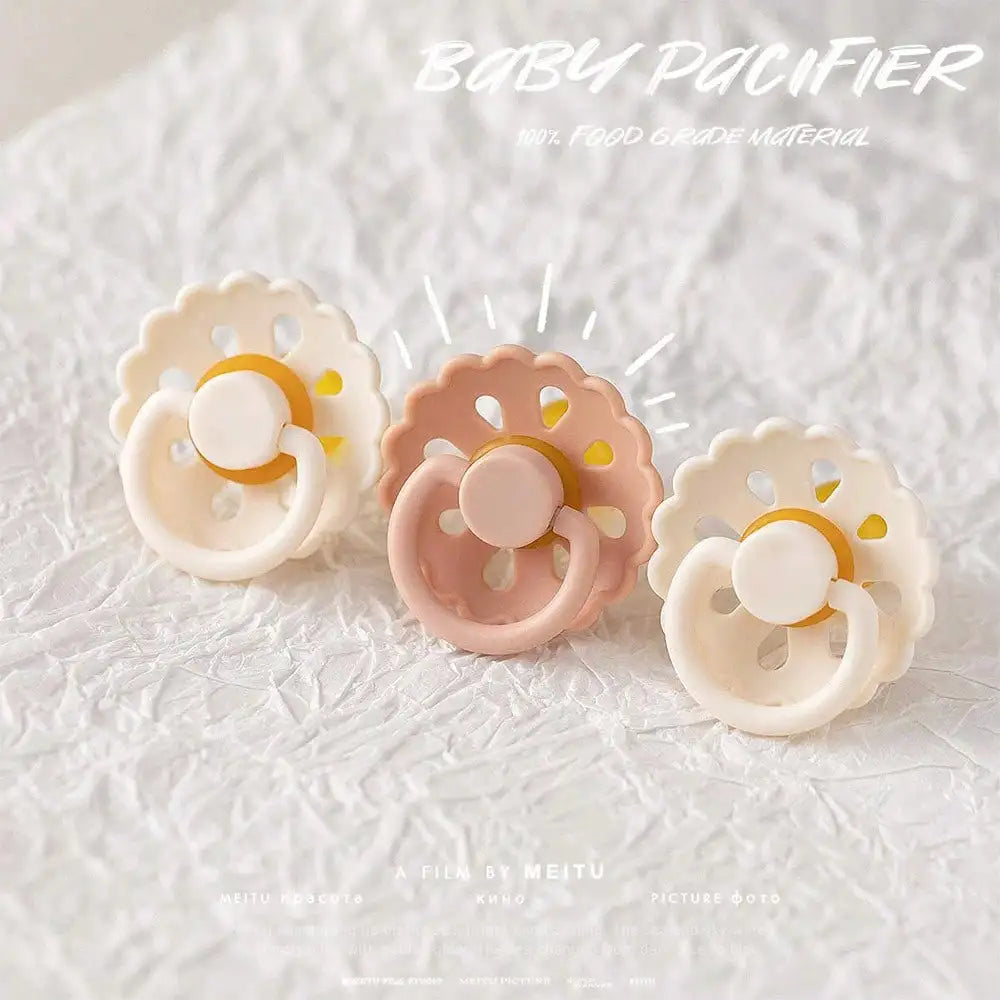 A set of light pink and white silicone baby pacifiers with a glow-in-the-dark feature displayed on a white background.