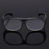 A pair of black ergonomic reading magnifying glasses with wide lenses shown against a dark background.