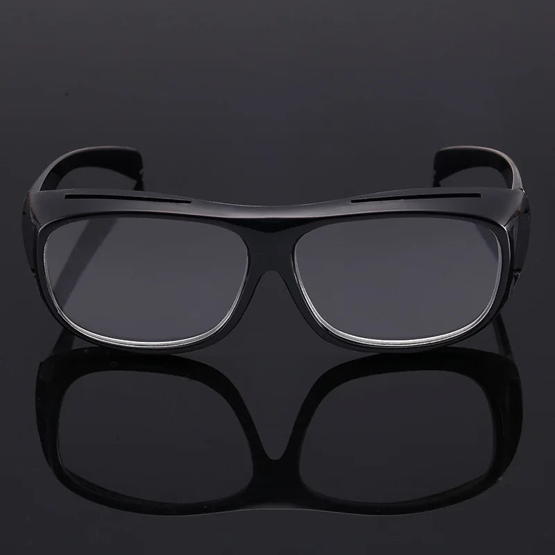 A pair of black ergonomic reading magnifying glasses with wide lenses shown against a dark background.