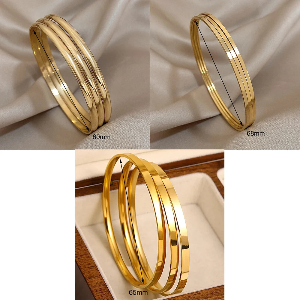 A set of minimalist gold-plated stainless steel bangles shown in various sizes and angles.