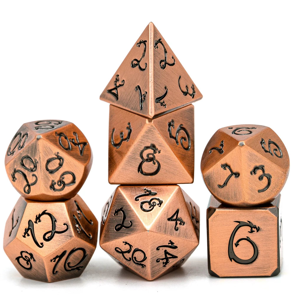A set of seven metal polyhedral dice with a dragon font design arranged in a pyramid and surrounding dice.