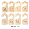 Set of eight wooden baby closet dividers for newborn to toddler sizes, featuring monthly age labels.