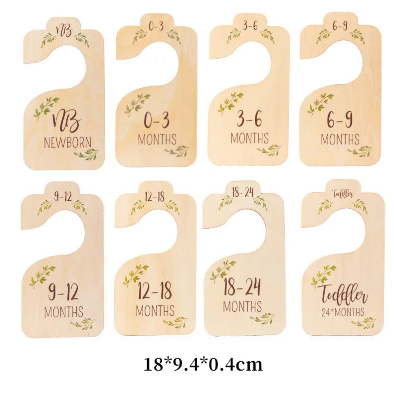 Set of eight wooden baby closet dividers for newborn to toddler sizes, featuring monthly age labels.