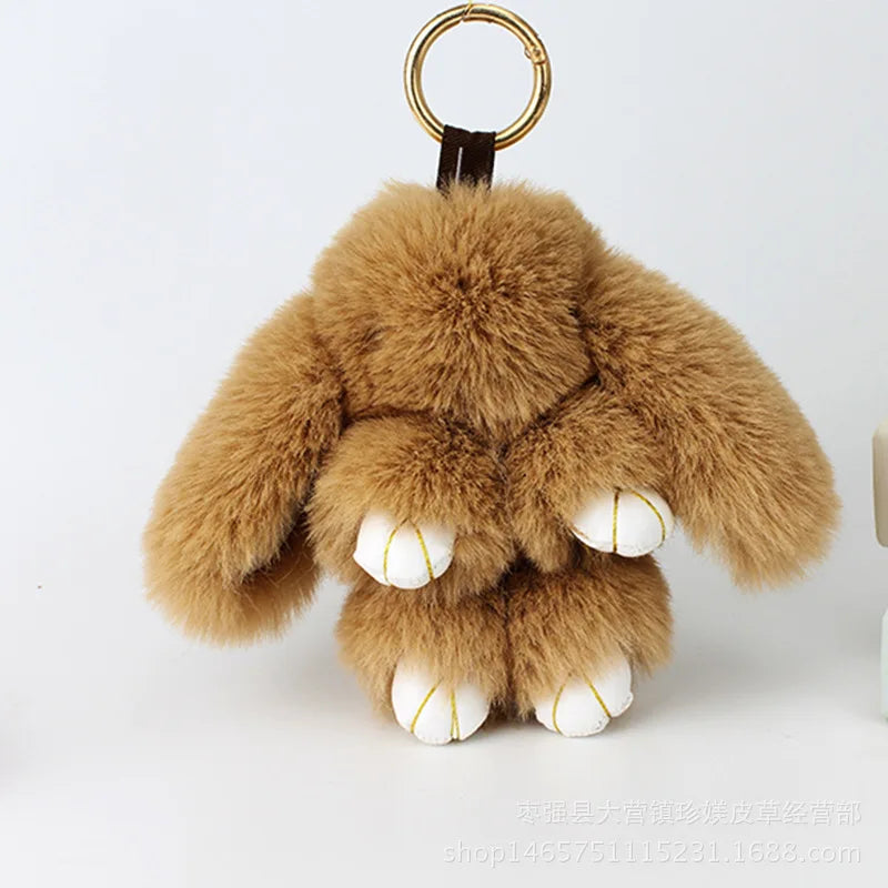 A fluffy brown bunny keychain featuring a pom pom tail and white paws.