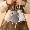 Three fluffy gray and white plush mouse stuffed animals hanging from a keychain loop