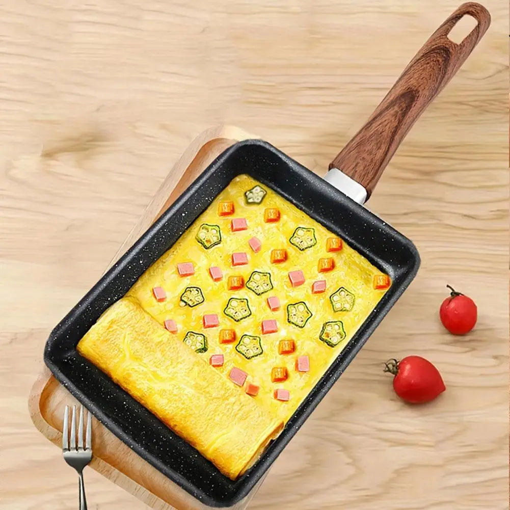 A mini square non-stick pan filled with scrambled eggs and diced vegetables, resting on a wooden board.