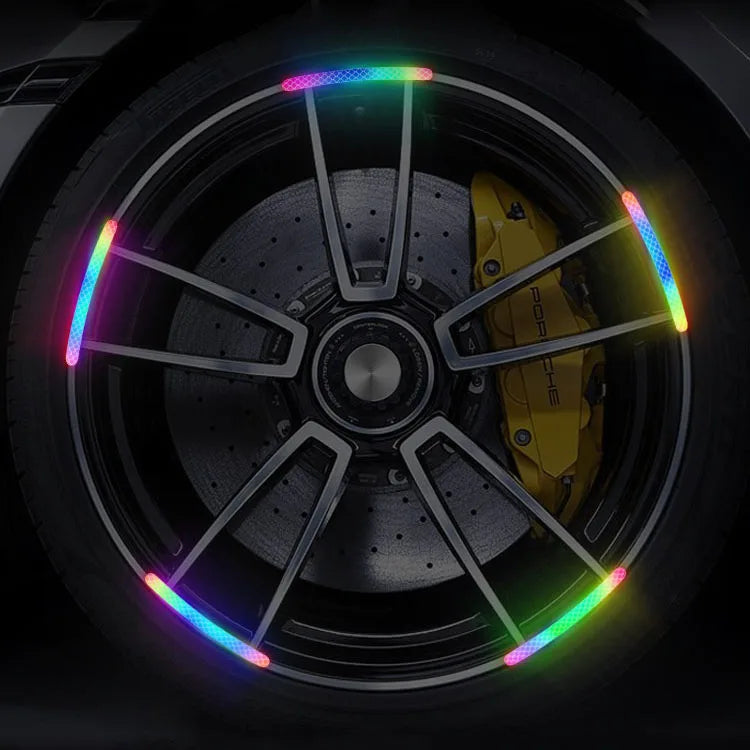 Close-up of a car wheel rim with colorful reflective stickers on the spokes.