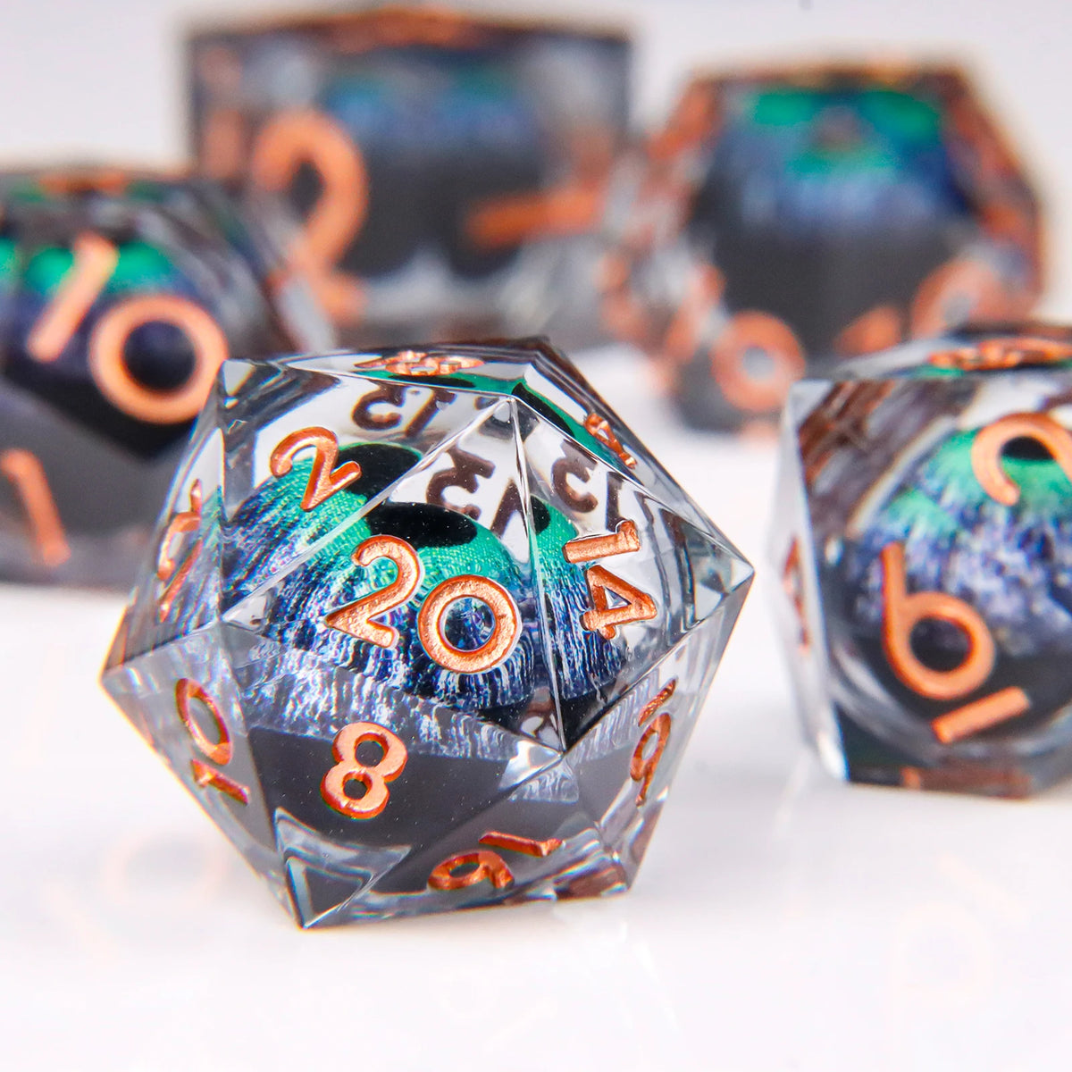 A close-up view of a translucent resin die with a dragon eye design and orange numbers on a white surface.