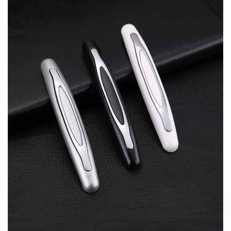 Three silver and black car door edge protector strips displayed on a dark surface.