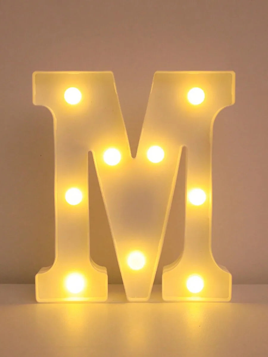 A glowing yellow LED letter M night light for home and party decor.