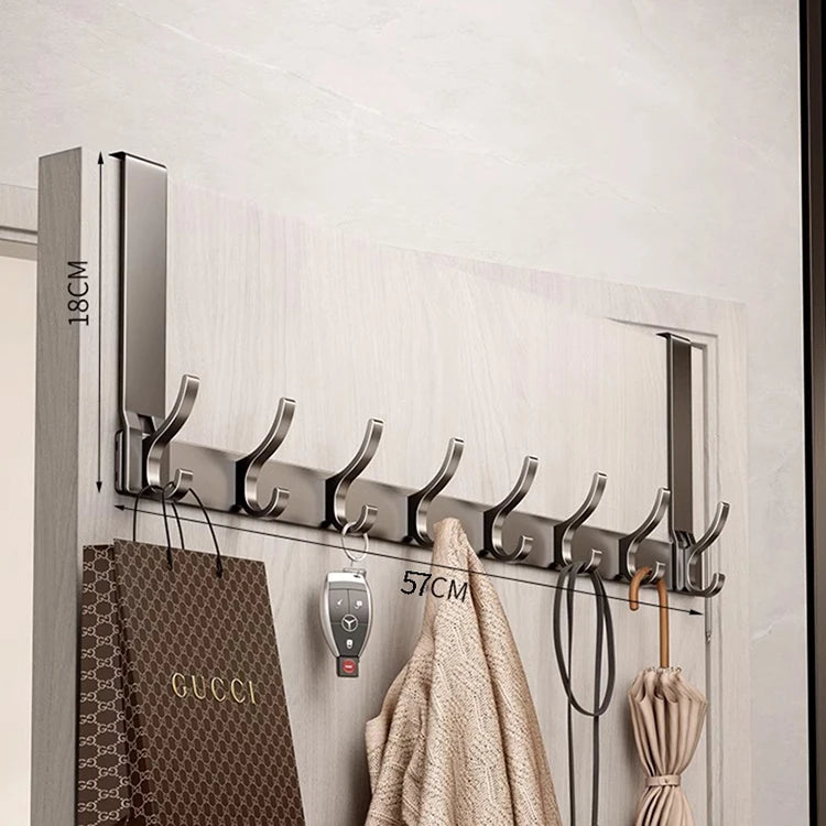 A silver over-the-door organizer rack with eight hooks mounted on a white door panel.