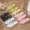 A collection of foldable EVA travel slippers in various pastel colors, including yellow, cream, pink, and black, laid out on 