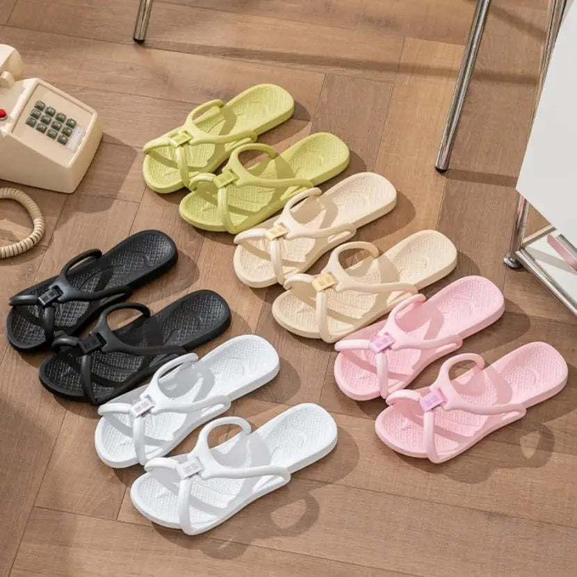 A collection of foldable EVA travel slippers in various pastel colors, including yellow, cream, pink, and black, laid out on 