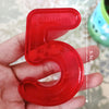 A red plastic number 5 counting tool is held in a hand, showing its size and shape.