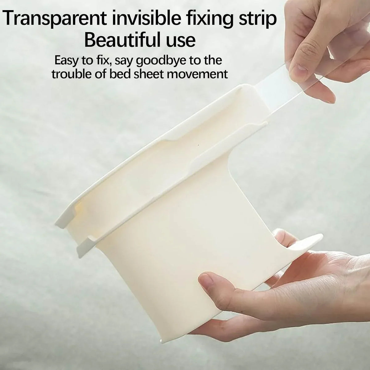 A hand is holding a transparent invisible fixing strip used to secure bed sheets, demonstrating its beautiful use.