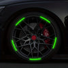 Close-up of a car wheel with bright green reflective stickers illuminating the spokes and rim.