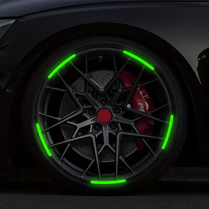 Close-up of a black car wheel with bright green reflective stickers on the rim.