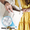 A hand is holding a beige disposable towel bag with a strap, showing the easy to carry feature.