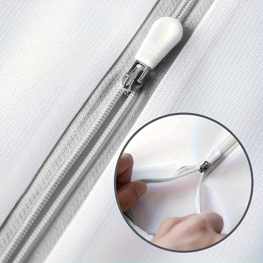 Close-up view of a silver zipper on a white fabric, showing the fine mesh material.