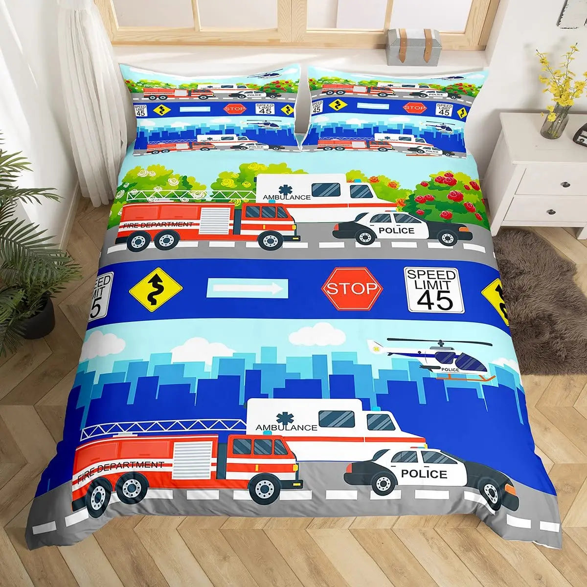 A colorful duvet cover set featuring various emergency vehicles like ambulances, police cars, and fire engines on a blue back
